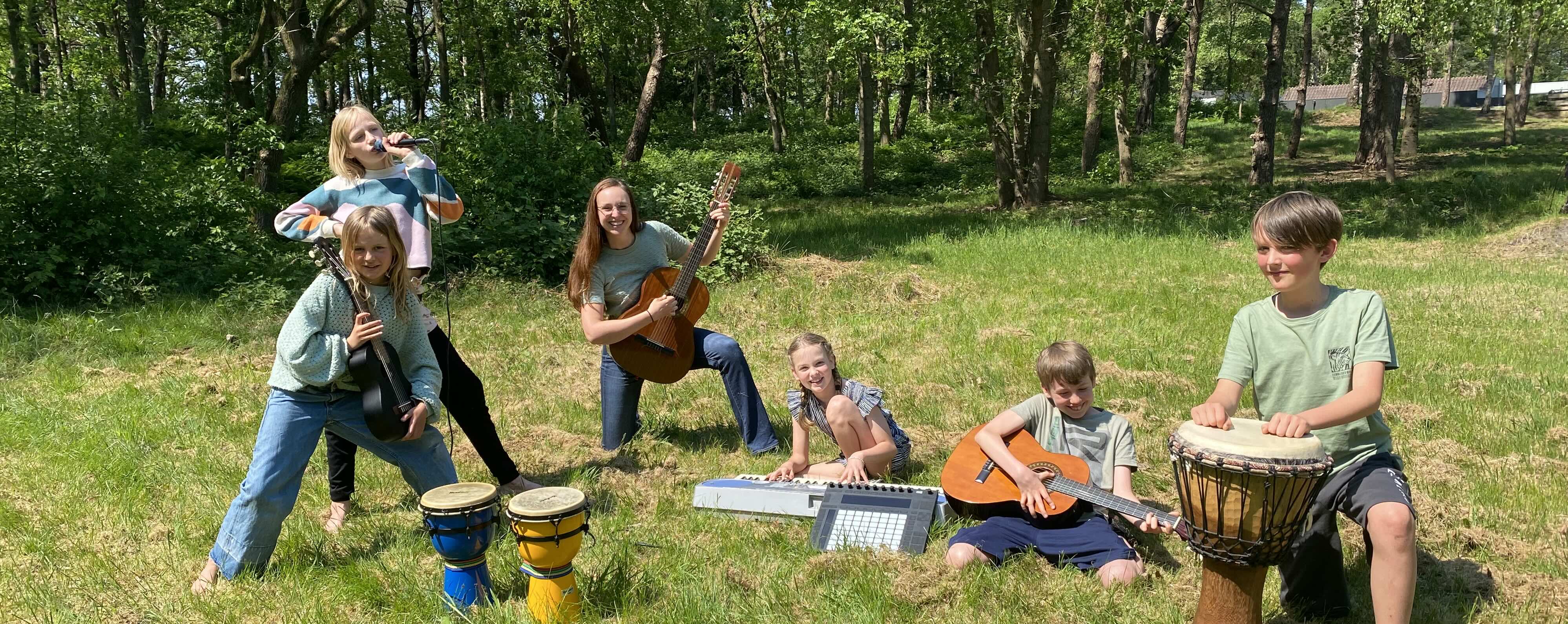 Een foto van Kayleigh Beard met leerlingen buiten met muziekinstrumenten
