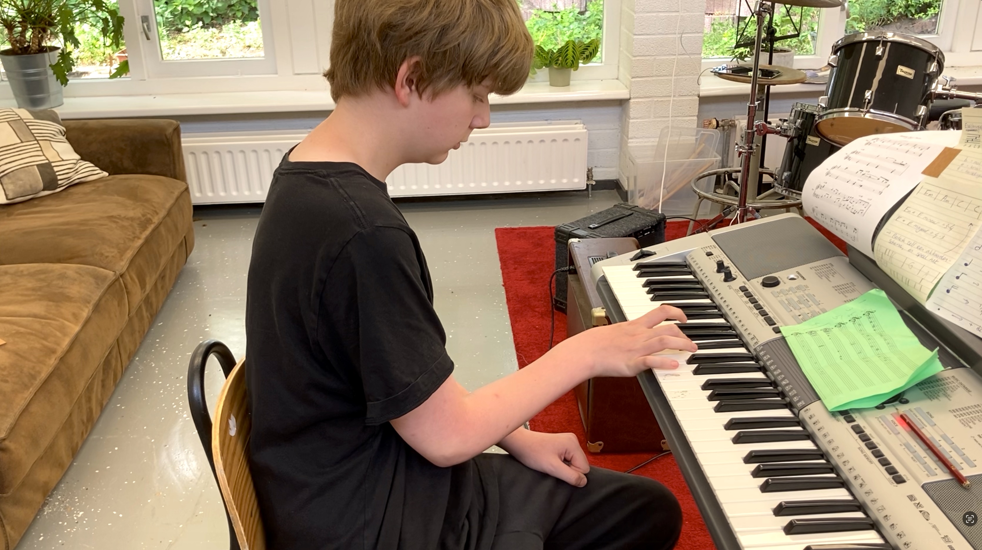 Foto van een leerling achter een keyboard